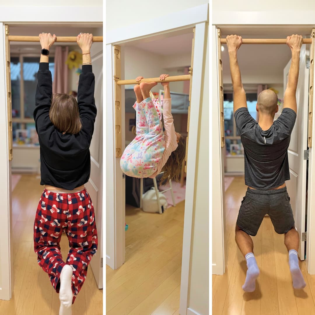 three people hanging fromt he pullup bar